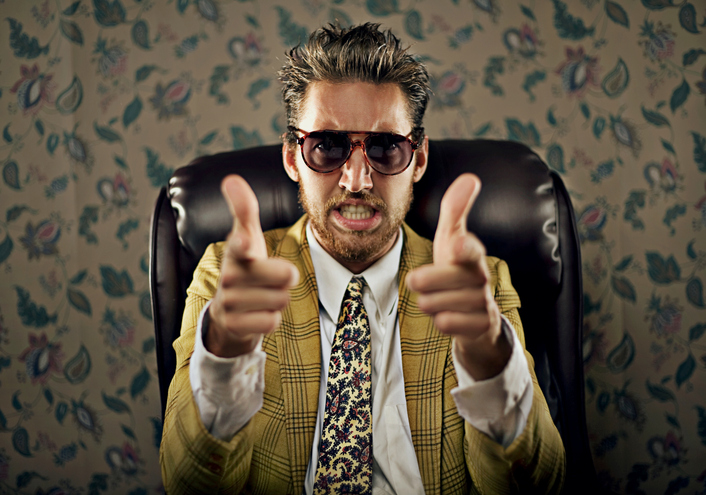 guy in yellow suit with gun fingers and shades