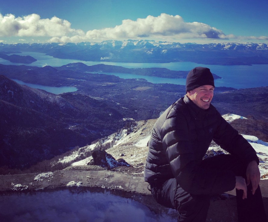 picture of a man on top of a mountain smiling